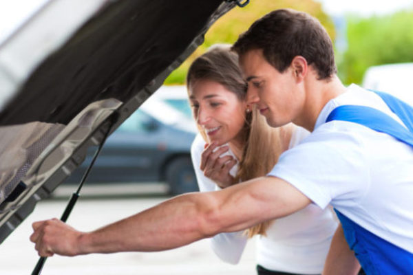 Woman telling a mechanic what’s wrong with her car mobile payments